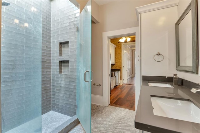 full bathroom with a shower stall, vanity, and baseboards