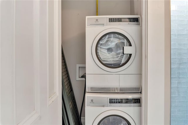 washroom featuring stacked washer and clothes dryer