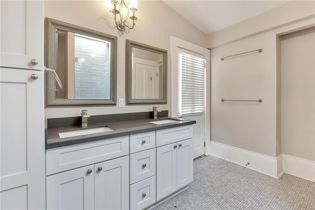 bathroom with tile patterned flooring, vanity, a chandelier, and vaulted ceiling