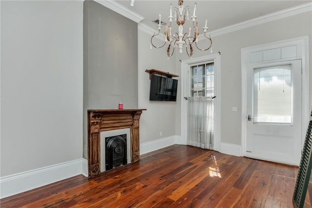 unfurnished living room featuring dark wood-type flooring, a notable chandelier, a healthy amount of sunlight, and crown molding