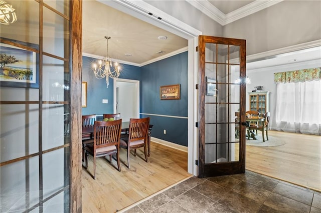 dining room featuring dark wood-type flooring, a notable chandelier, and ornamental molding