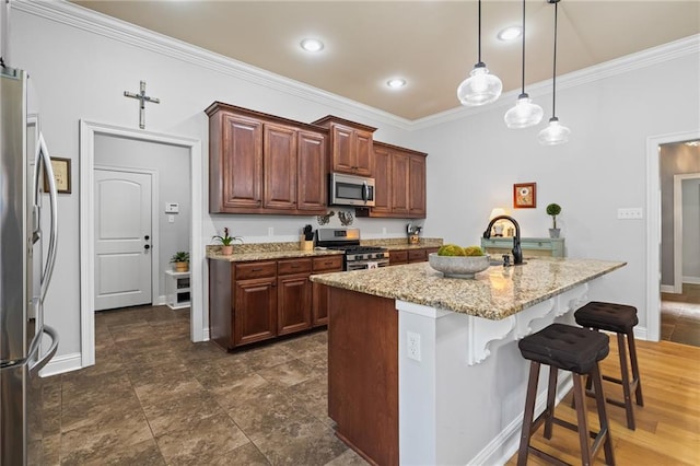 kitchen featuring a breakfast bar area, a kitchen island with sink, light stone countertops, pendant lighting, and appliances with stainless steel finishes