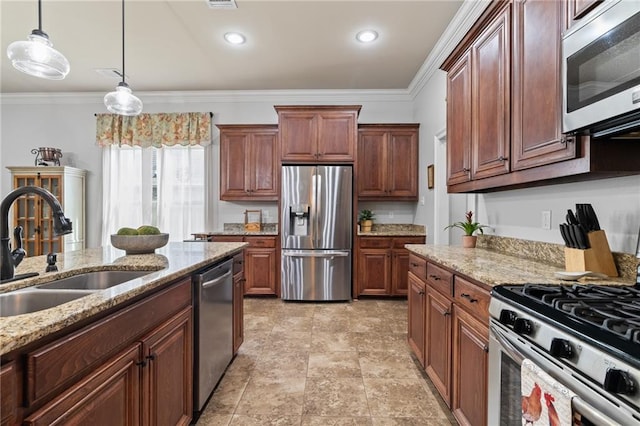 kitchen with light stone counters, ornamental molding, appliances with stainless steel finishes, pendant lighting, and sink