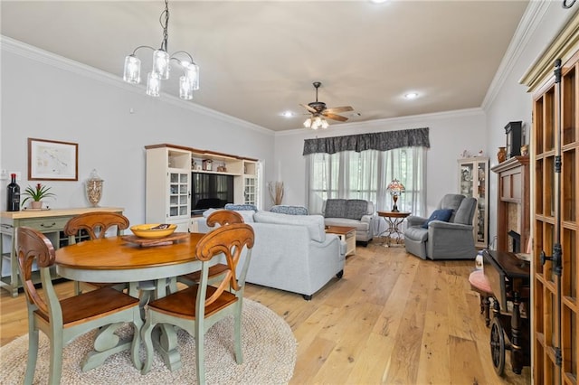 dining area featuring ornamental molding, ceiling fan with notable chandelier, and light hardwood / wood-style flooring