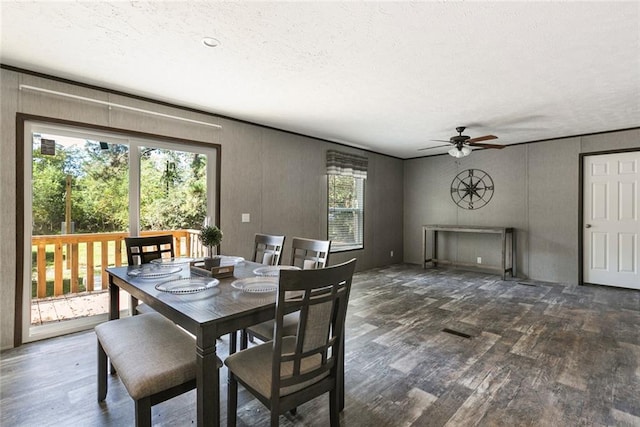 dining space featuring a textured ceiling, dark wood-type flooring, a healthy amount of sunlight, and ceiling fan