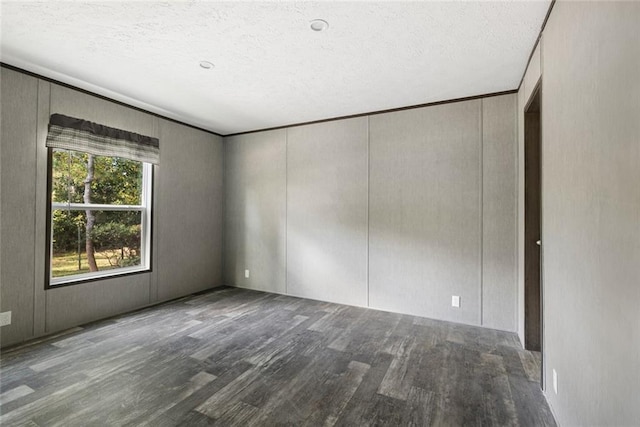 spare room featuring wood-type flooring and a textured ceiling