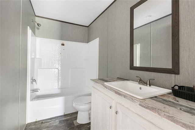 full bathroom featuring ornamental molding, tub / shower combination, wood-type flooring, vanity, and toilet