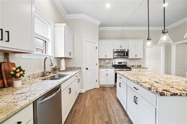 kitchen featuring white cabinetry, appliances with stainless steel finishes, pendant lighting, hardwood / wood-style floors, and sink