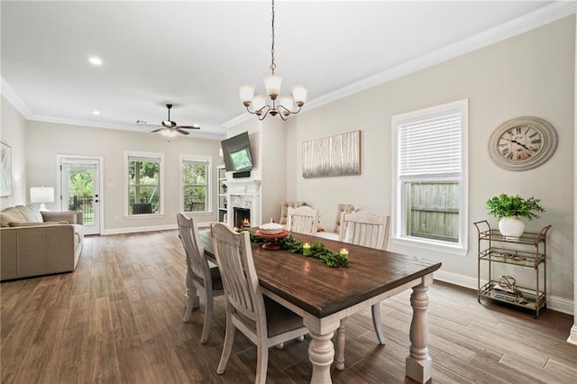 dining space with wood-type flooring, crown molding, and ceiling fan with notable chandelier