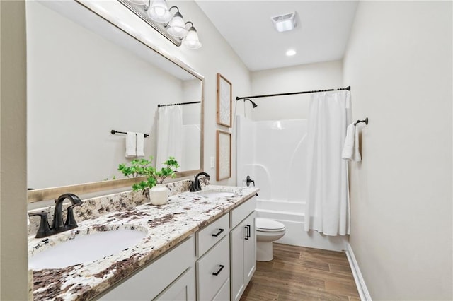 full bathroom featuring wood-type flooring, vanity, toilet, and shower / tub combo