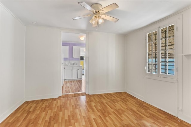 unfurnished room with light hardwood / wood-style floors, ceiling fan, and crown molding