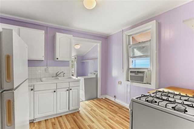 639 Independence St, New Orleans, LA 70117 - kitchen featuring white appliances, white cabinets, light wood-style flooring, light countertops, and crown molding