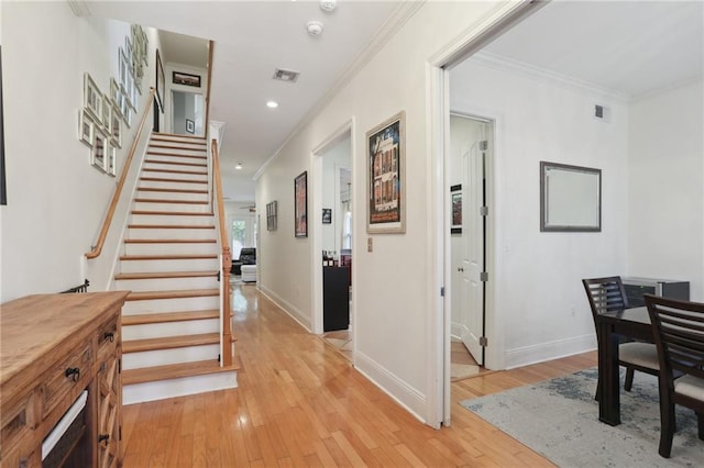 foyer entrance featuring ornamental molding and light hardwood / wood-style floors