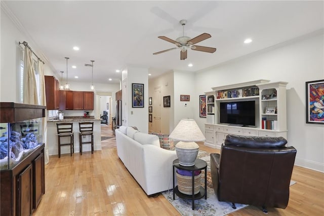 living room featuring light hardwood / wood-style floors, ceiling fan, and ornamental molding