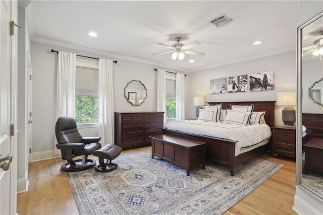 bedroom featuring ceiling fan, multiple windows, and light hardwood / wood-style flooring