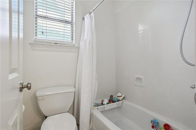 bathroom featuring a shower with shower curtain and toilet