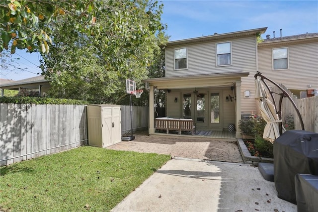 back of property with a lawn and a shed