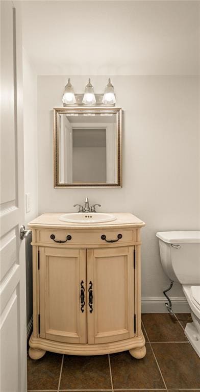 bathroom featuring tile patterned flooring, vanity, and toilet