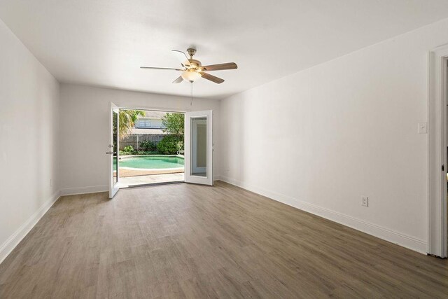 empty room with hardwood / wood-style floors and ceiling fan