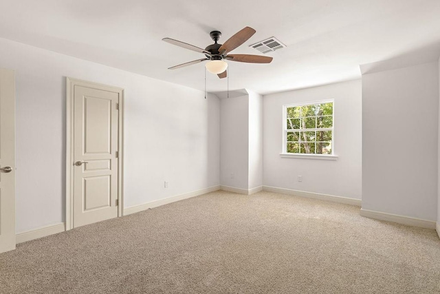 carpeted spare room featuring ceiling fan