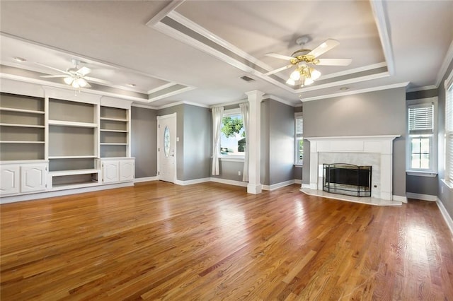 unfurnished living room featuring a tray ceiling, hardwood / wood-style flooring, and ceiling fan