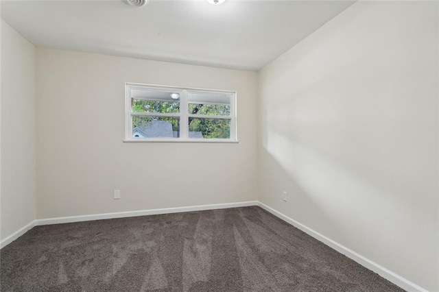 empty room featuring dark carpet