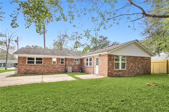 back of property with central AC unit and a yard