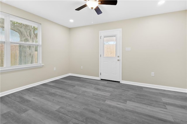 empty room with dark wood-type flooring, ceiling fan, and plenty of natural light