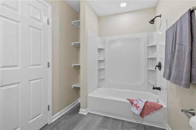 bathroom featuring wood-type flooring and shower / bathtub combination