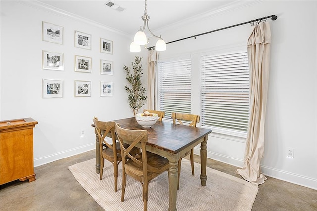 dining space featuring concrete floors, an inviting chandelier, and crown molding