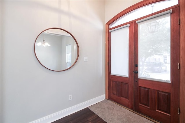 entryway featuring an inviting chandelier and wood-type flooring