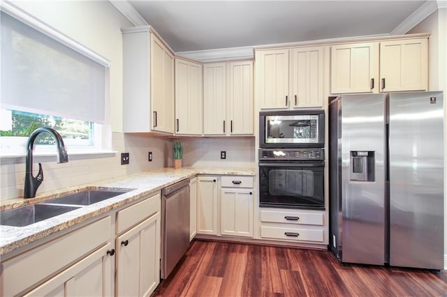 kitchen with ornamental molding, stainless steel appliances, dark hardwood / wood-style floors, sink, and cream cabinetry