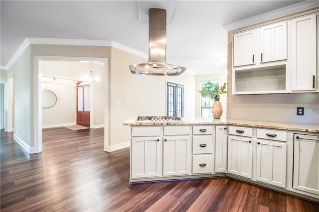 kitchen with kitchen peninsula, light stone countertops, island range hood, dark wood-type flooring, and decorative backsplash