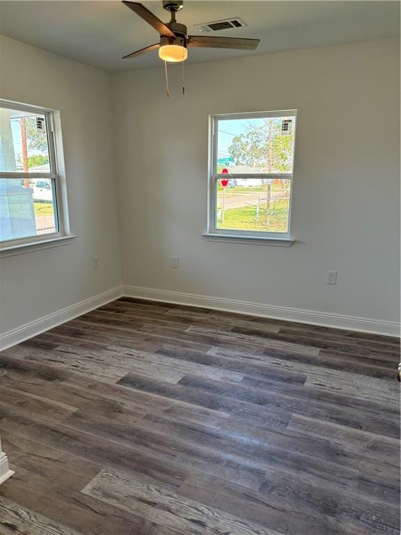 spare room with dark wood-type flooring and ceiling fan