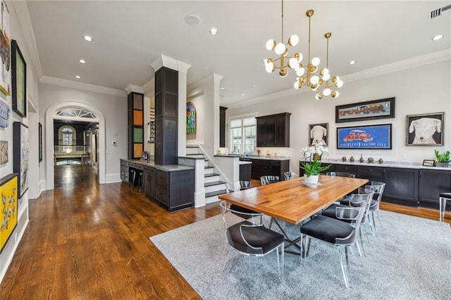 dining area featuring dark wood-type flooring, crown molding, and an inviting chandelier