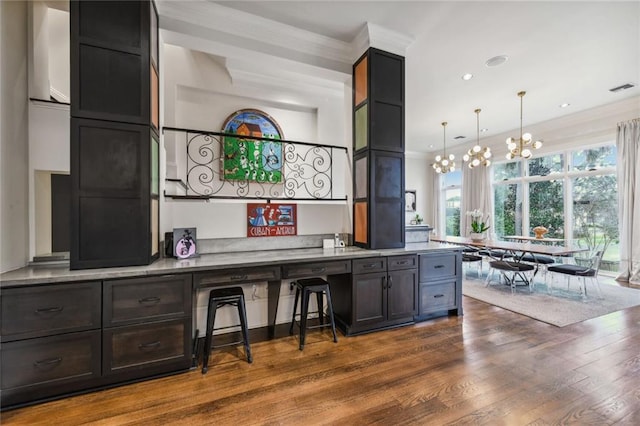 kitchen featuring crown molding, hanging light fixtures, dark hardwood / wood-style floors, and an inviting chandelier