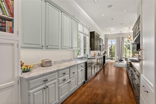 kitchen featuring light stone countertops, sink, dark hardwood / wood-style flooring, crown molding, and pendant lighting