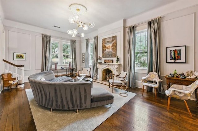 living area featuring plenty of natural light, dark hardwood / wood-style flooring, and an inviting chandelier