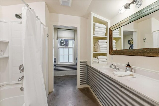 bathroom with shower / bath combo with shower curtain, sink, and concrete floors