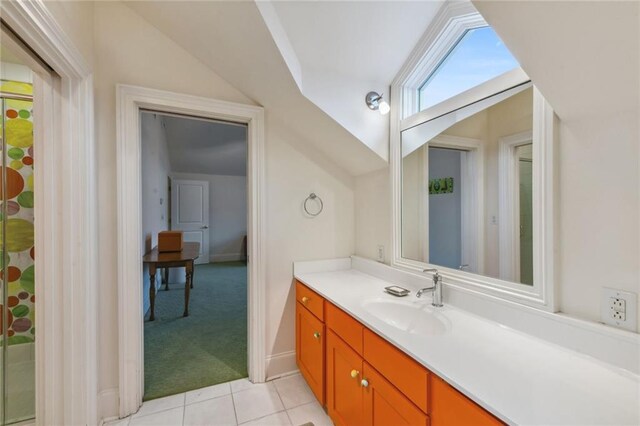 bathroom featuring tile patterned flooring, vanity, and lofted ceiling