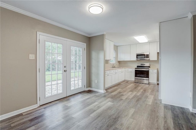 kitchen featuring french doors, crown molding, stainless steel appliances, light wood-type flooring, and white cabinetry