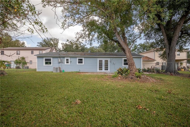 rear view of property featuring central air condition unit, a yard, and french doors