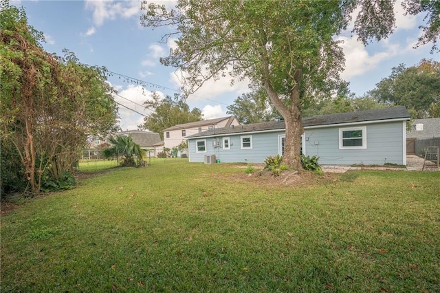 rear view of property with a lawn and cooling unit