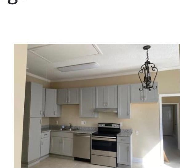 kitchen with gray cabinetry, stainless steel appliances, decorative light fixtures, a notable chandelier, and sink