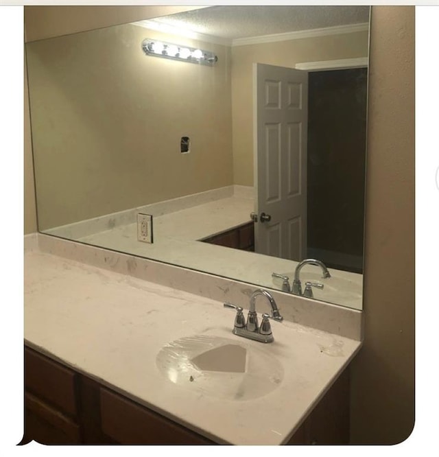 bathroom featuring vanity, a textured ceiling, and crown molding