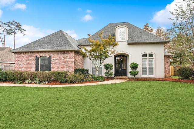 french provincial home with french doors and a front lawn