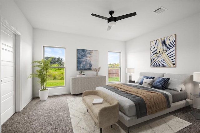 bedroom with multiple windows, light colored carpet, and ceiling fan