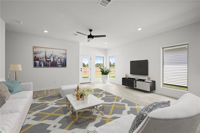 living room with light hardwood / wood-style floors and ceiling fan