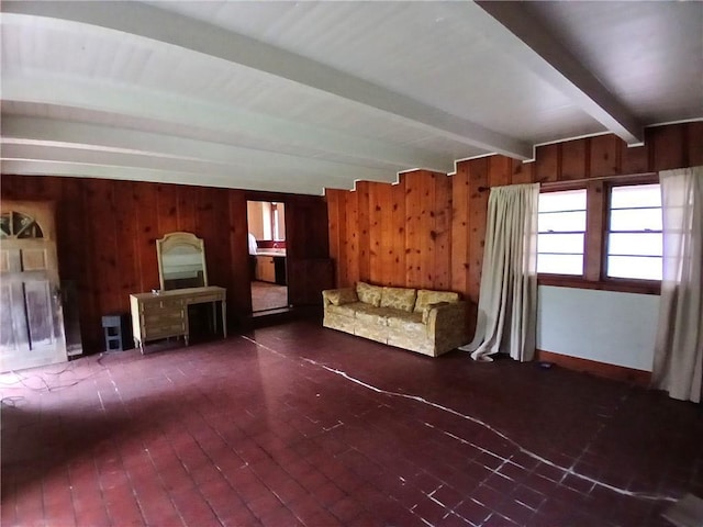 unfurnished living room with wood walls and beamed ceiling