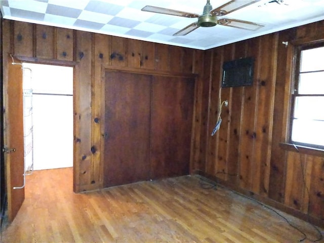 interior space featuring wooden walls, plenty of natural light, and light hardwood / wood-style flooring